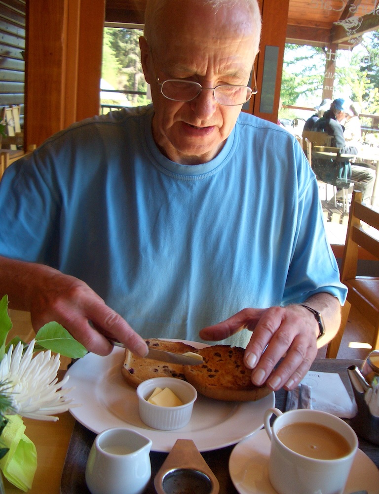 Peter at table buttering teacake.