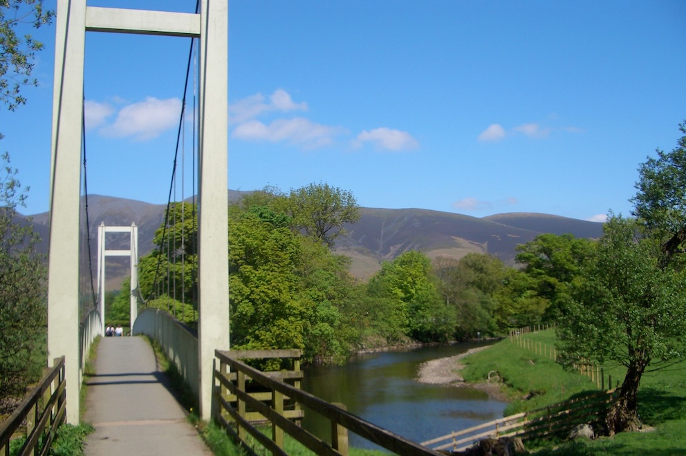 Suspension footbridge across river.