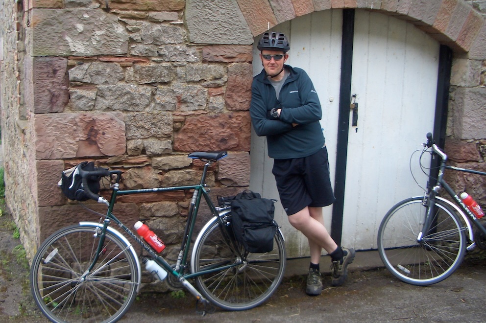 Me leaning in doorway with our bikes.