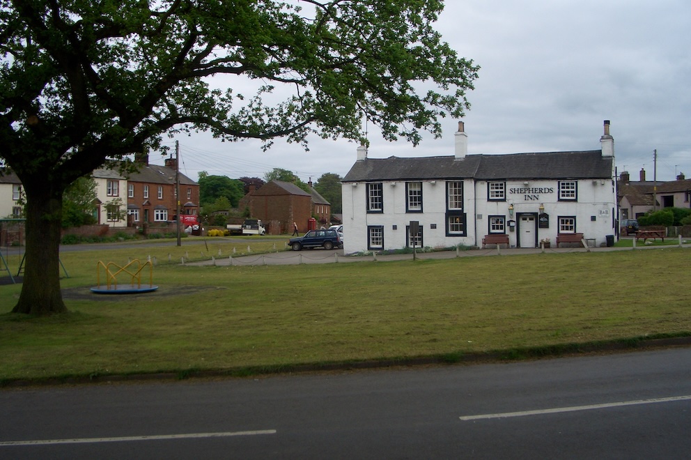 Village green with white pub on far side.