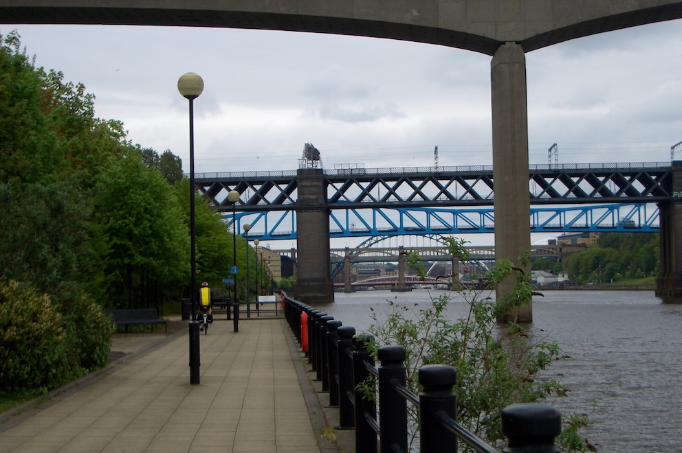 Riverside path with multiple bridges receding into distance.